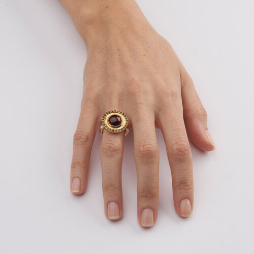 model wearing gold and garnet cocktail ring