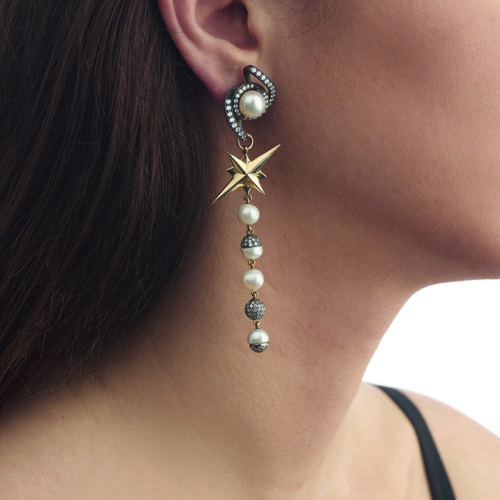 model wearing gold, silver, diamond, and pearl chandelier earring