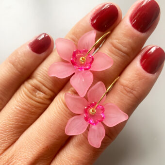 pink flower earrings in hand